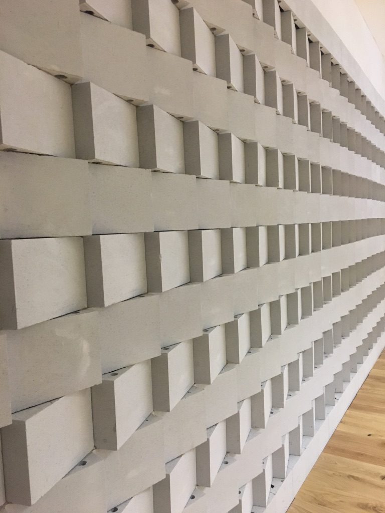 Détail rapproché d’un mur diffuseur acoustique gris en relief