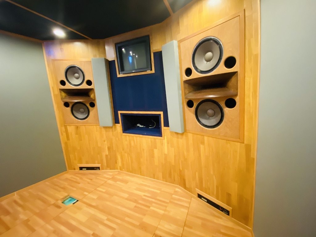 Détail d’enceintes encastrées dans un mur de studio en bois