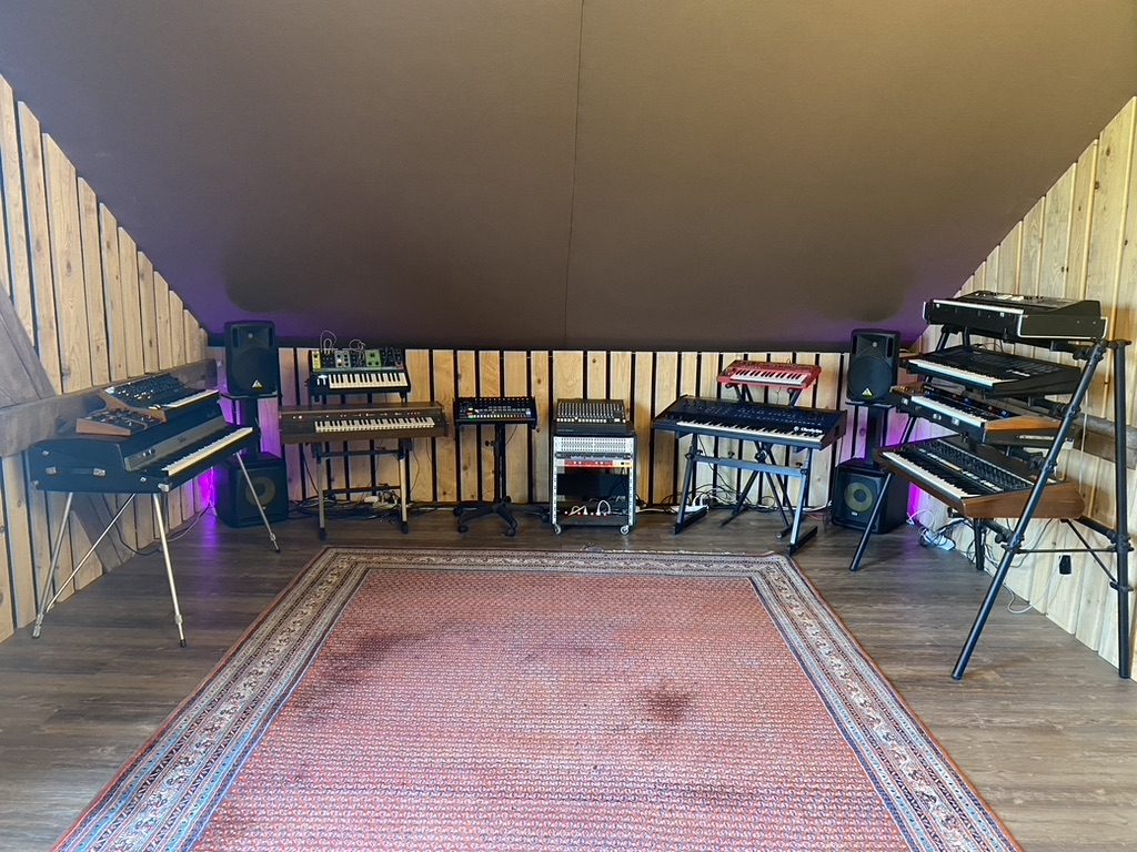 Espace musical avec claviers, synthétiseurs et rack audio