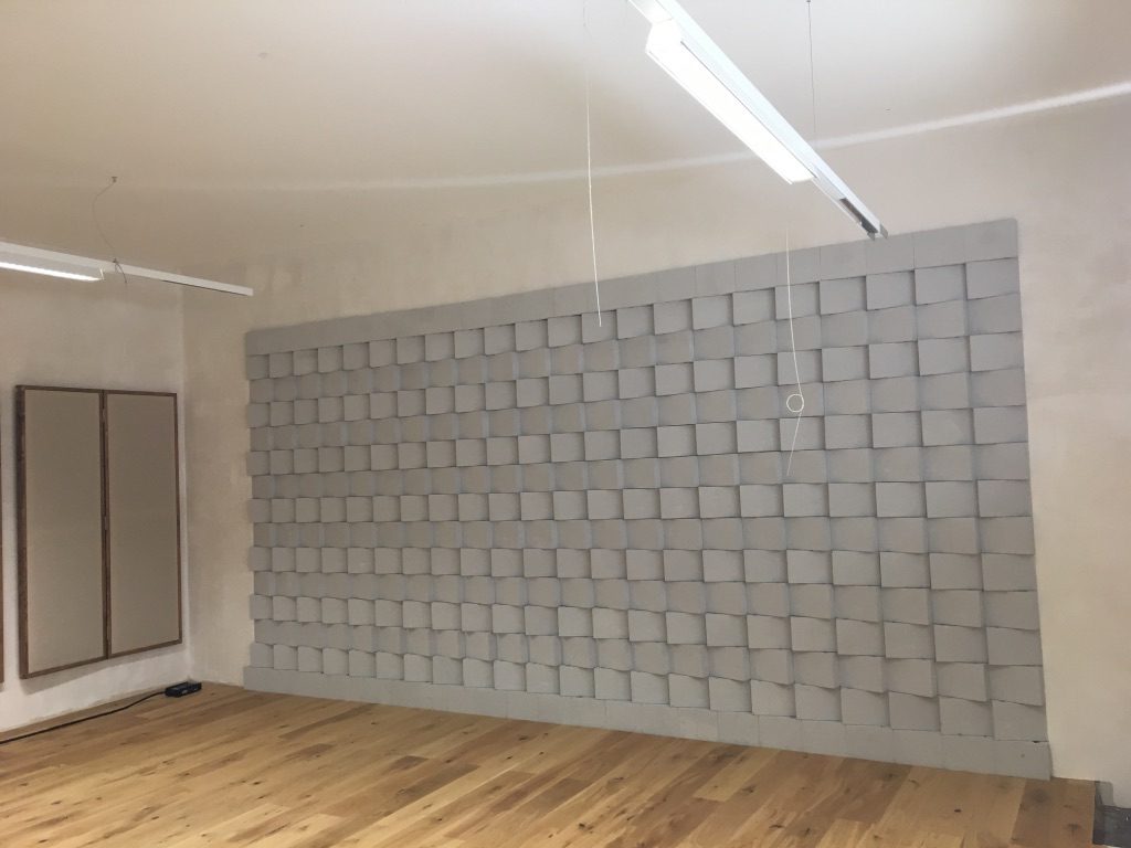 Grand mur diffuseur acoustique gris avec panneaux absorbants latéraux