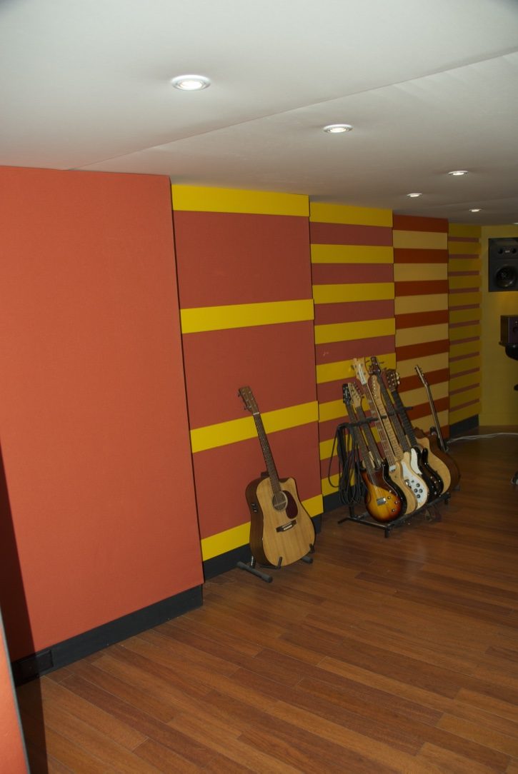 Mur acoustique orange et jaune avec guitares dans un studio