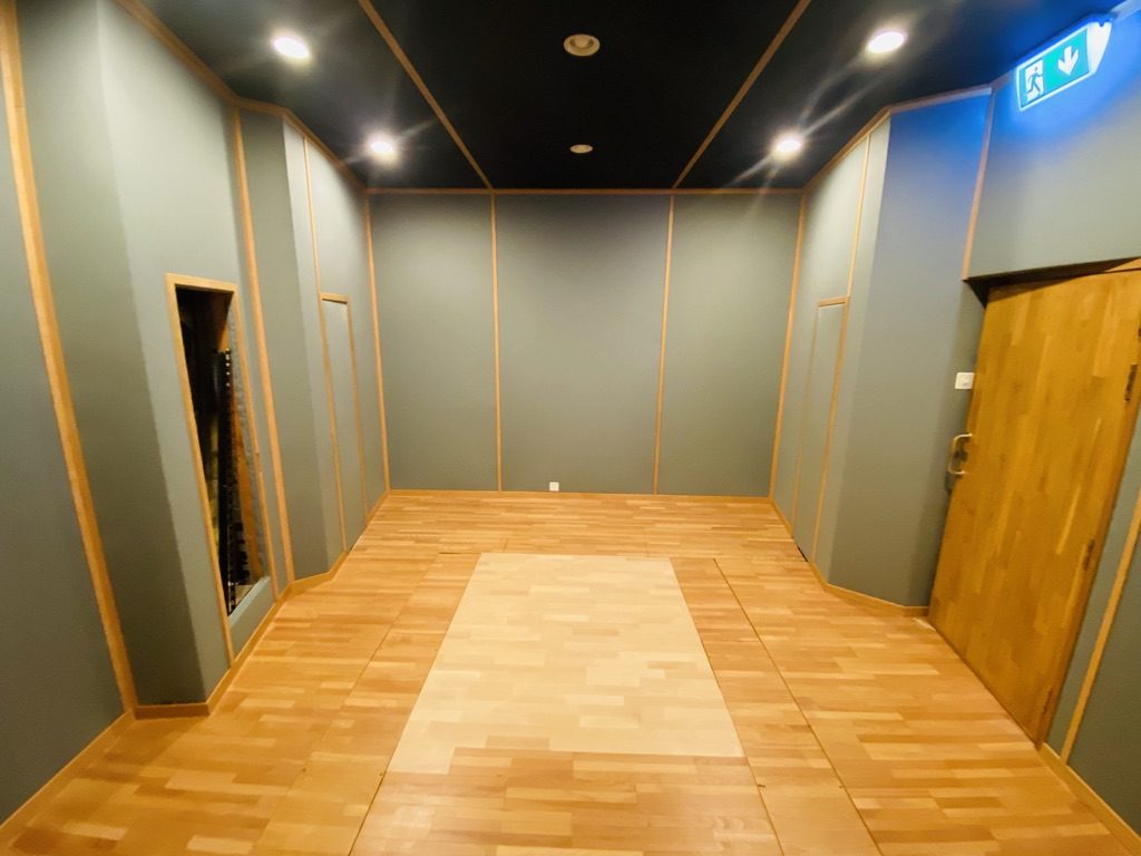 Arrière de régie bois avec plancher technique et panneaux acoustiques verts