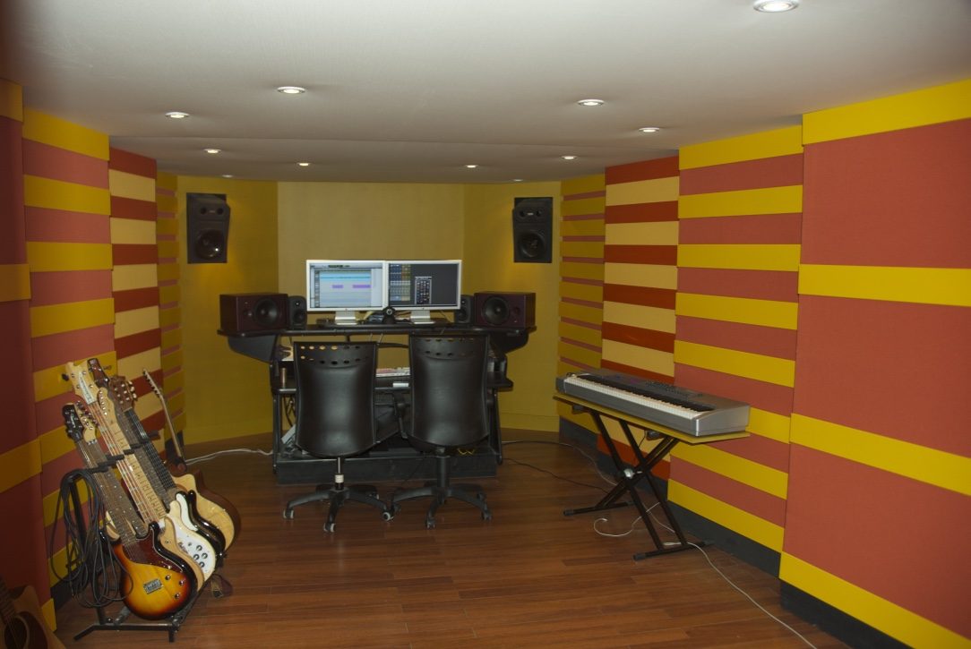 Studio coloré jaune et rouge avec instruments et poste de travail audio