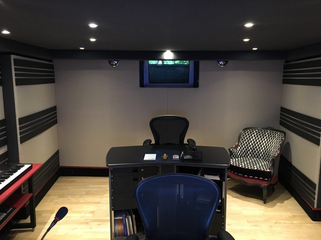 Studio avec bureau noir, fauteuils et traitement acoustique mural